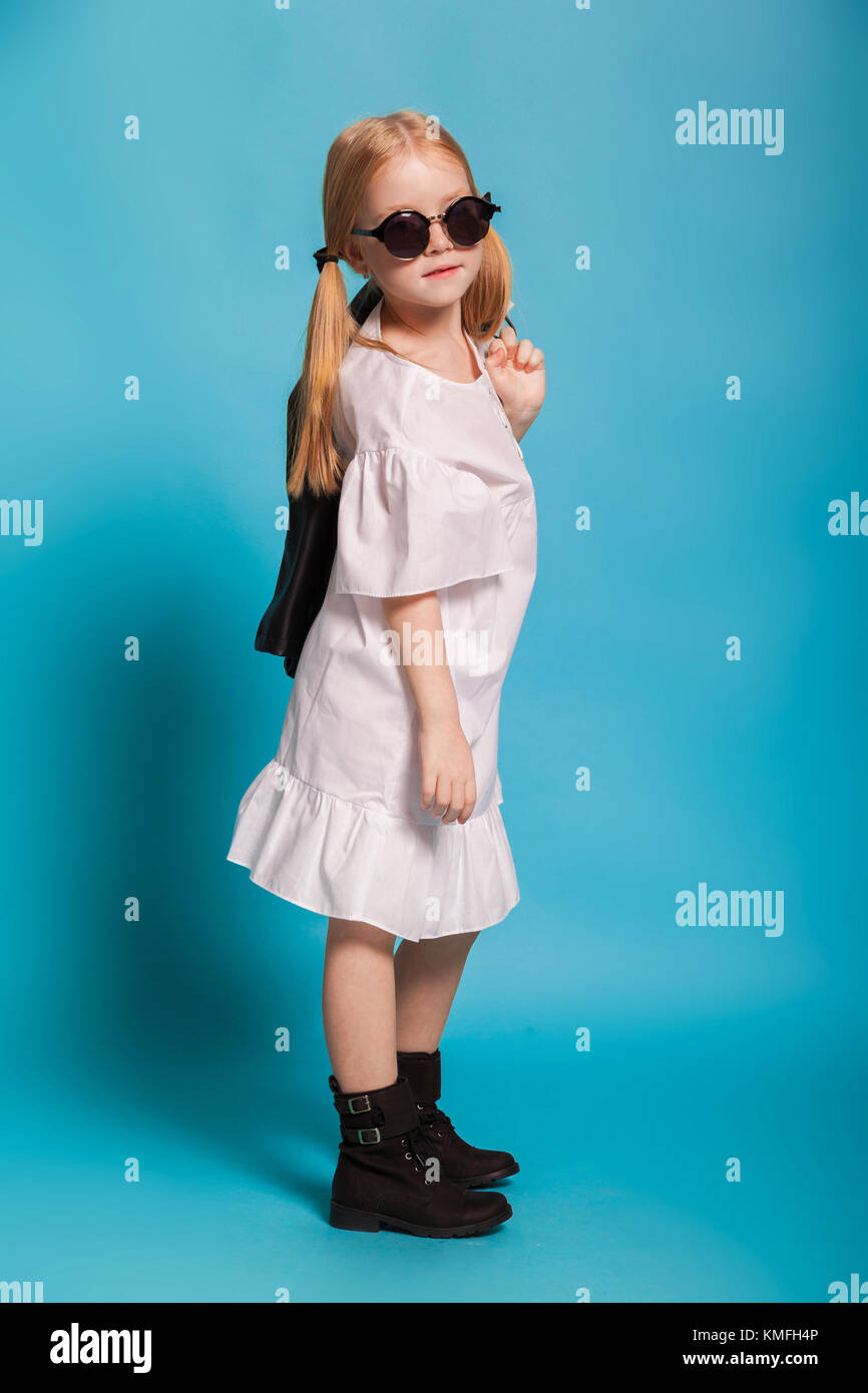 a little girl in the white dress and black shoes Stock Photo