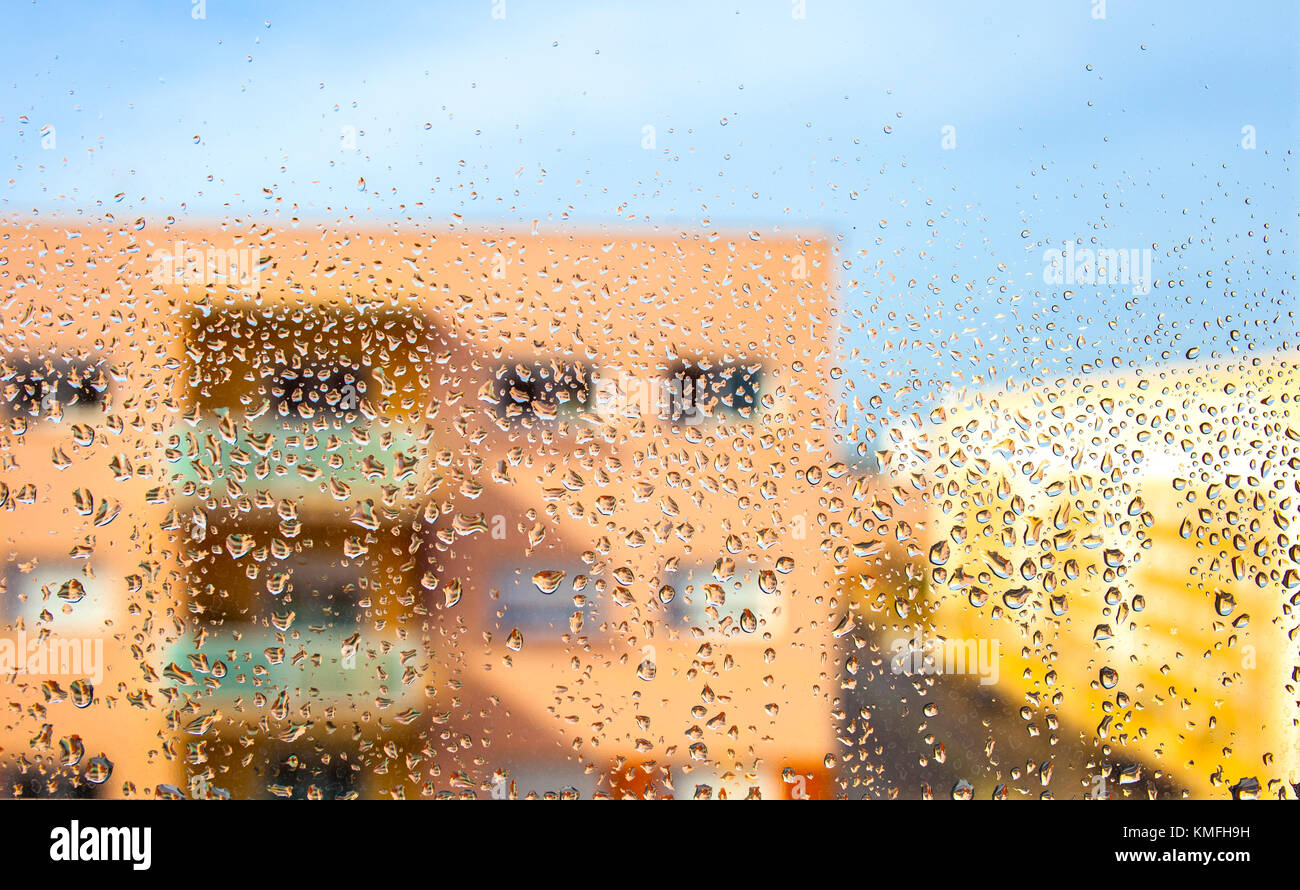 Rain drops on the glass in the background blurred flat building Stock Photo