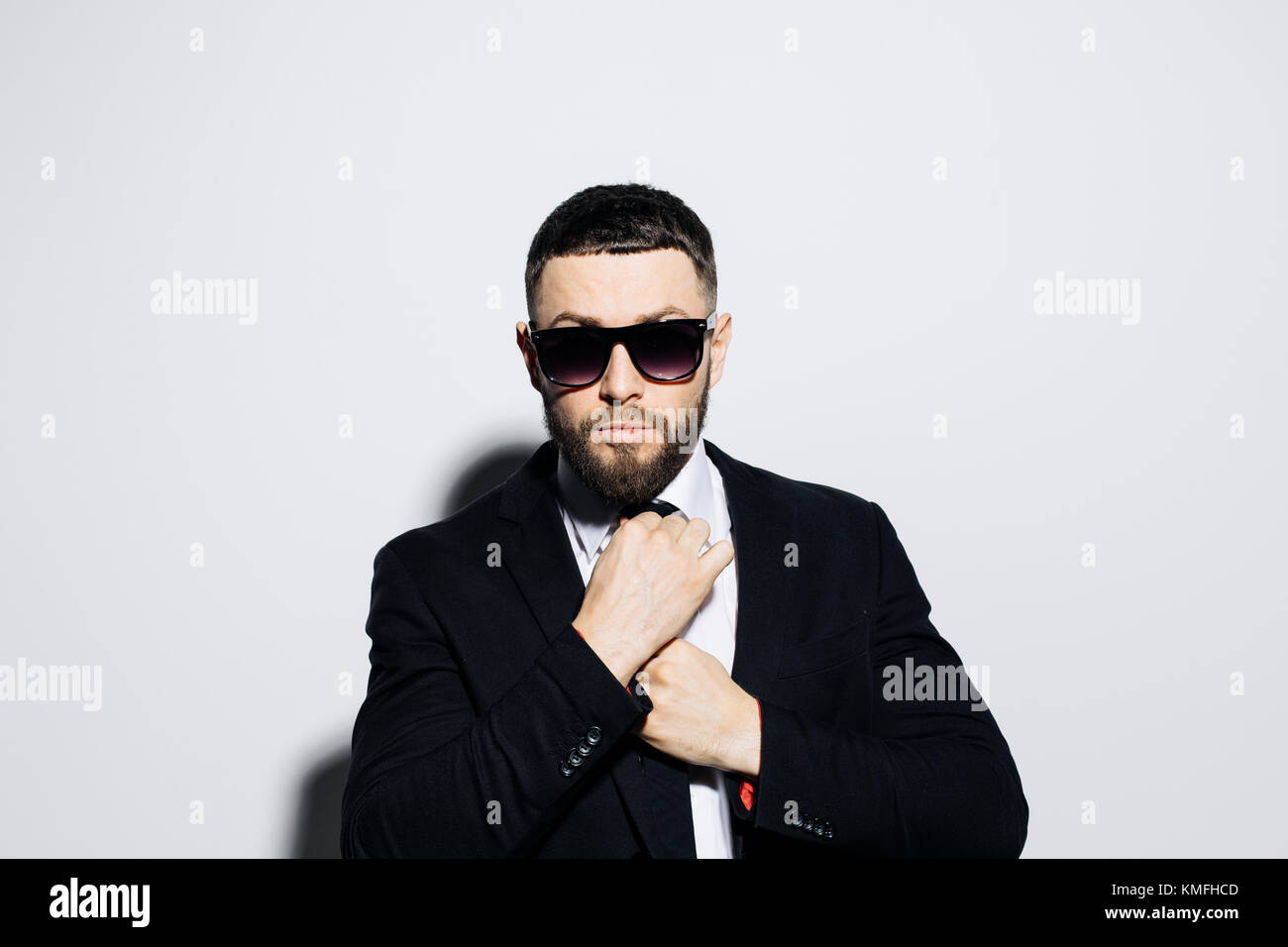Portrait of a handsome young man in suit and sunglasses posing while ...