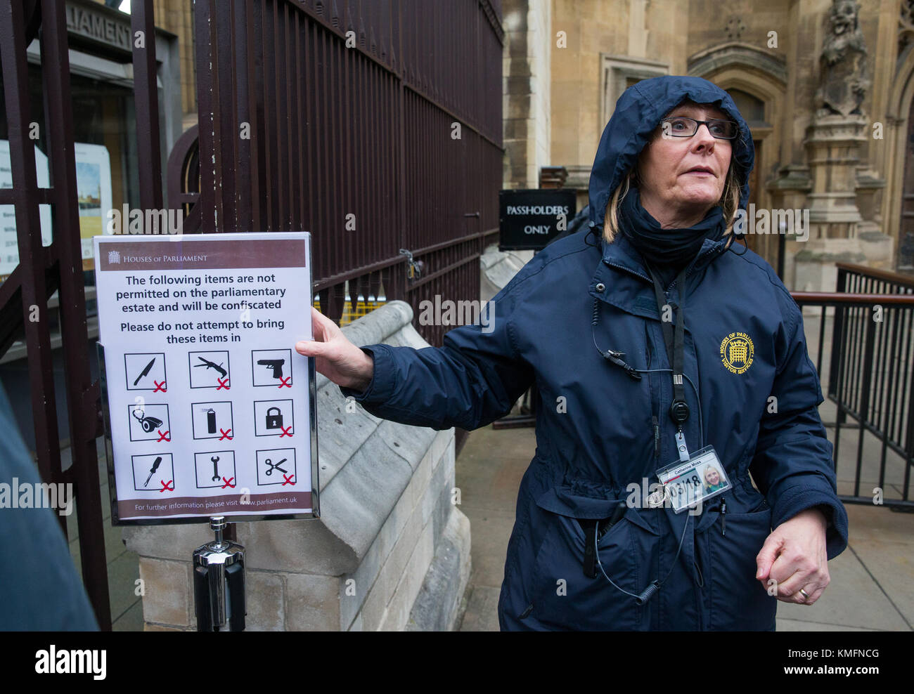 A Westminster official points out a sign showing the  items banned from Parliament including a gun, scissors, knife, aerosol,screwdriver and padlock. Stock Photo