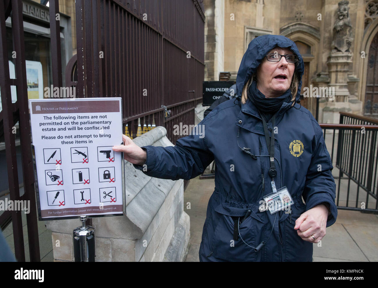 A Westminster official points out a sign showing the  items banned from Parliament including a gun, scissors, knife, aerosol,screwdriver and padlock. Stock Photo