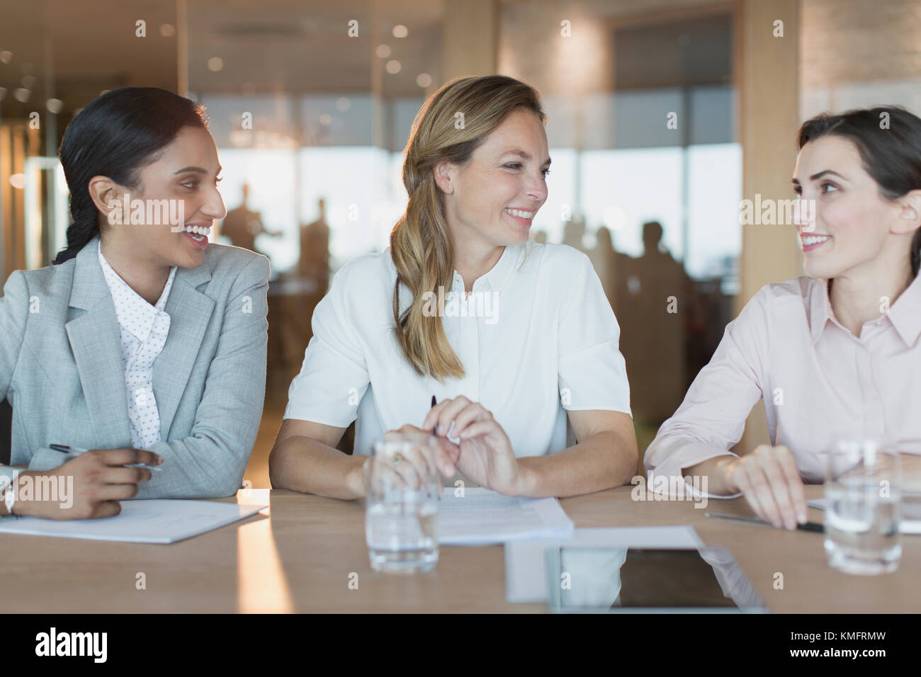 Smiling businesswomen talk in conference room meeting Stock Photo