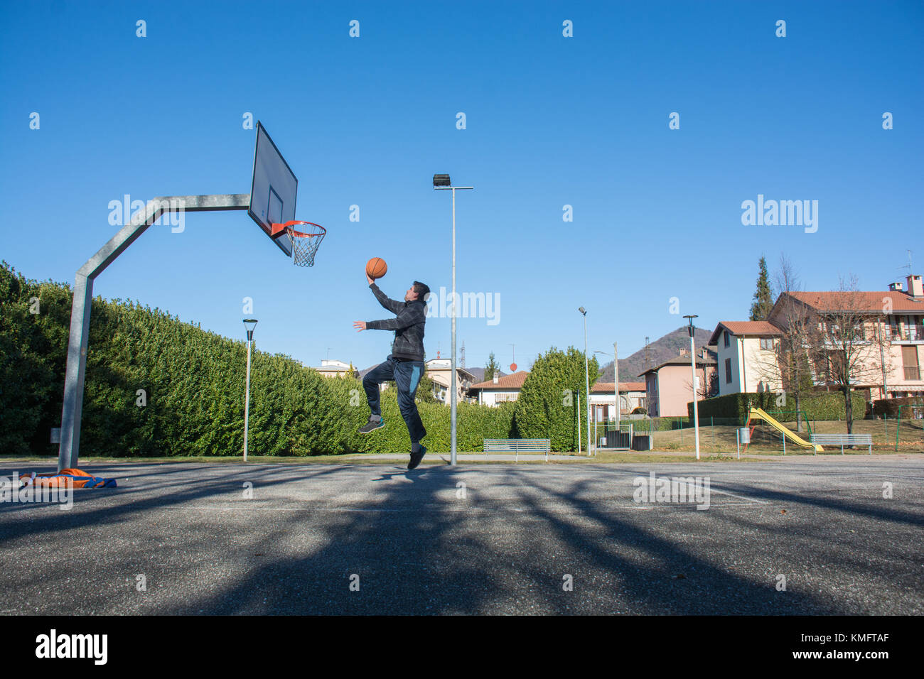 Italian guy playing basketball on playground court Stock Photo