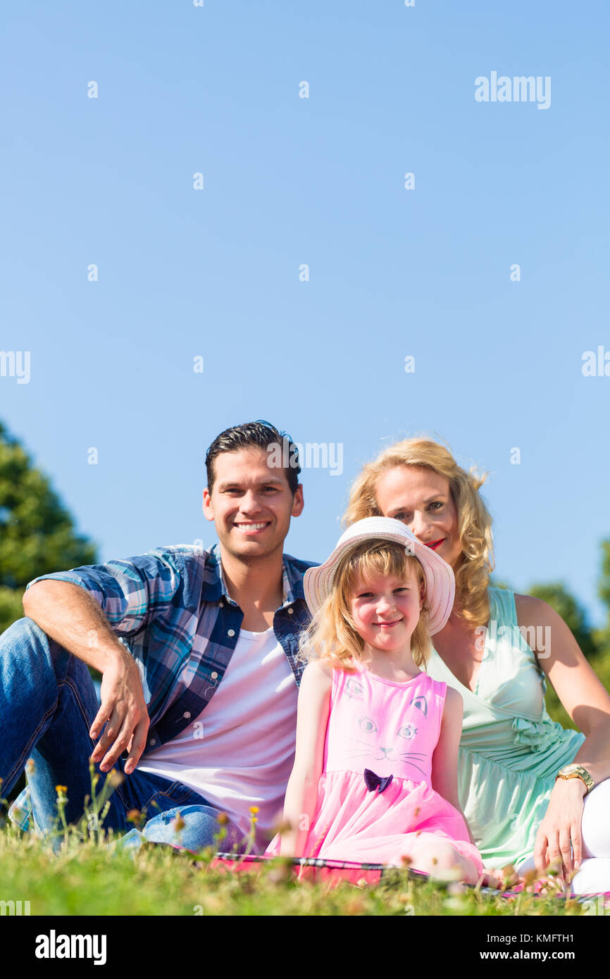 Family photo with father, mother and daughter in meadow in Summer Stock Photo