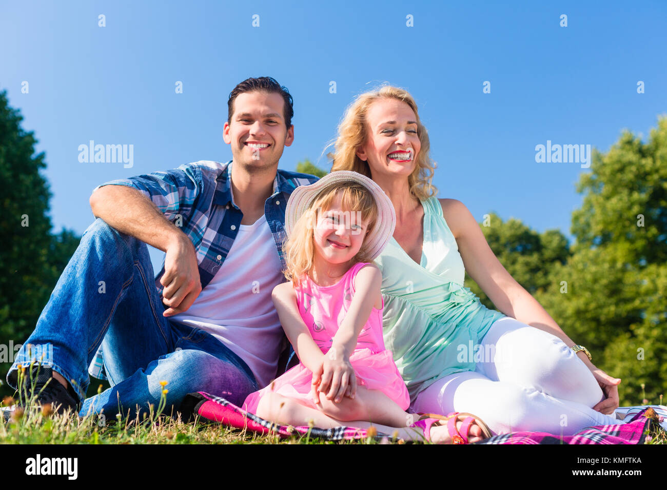 Family photo with father, mother and daughter in meadow in Summer Stock Photo