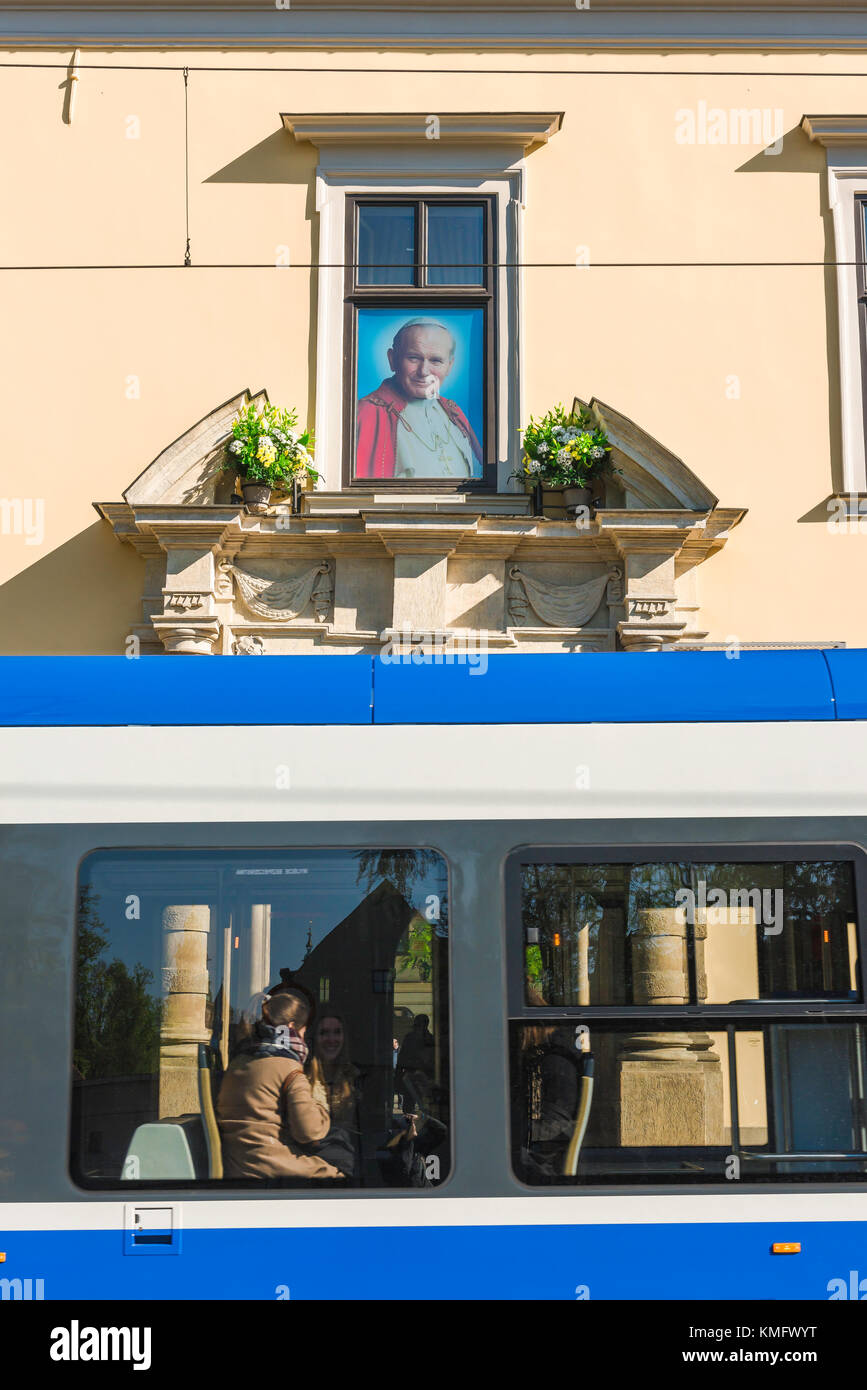 Krakow Archbishop's Palace, a tram passes below the famous 'Pope Window' showing John Paul ll above the entrance to the Archbishop's Palace, Krakow. Stock Photo