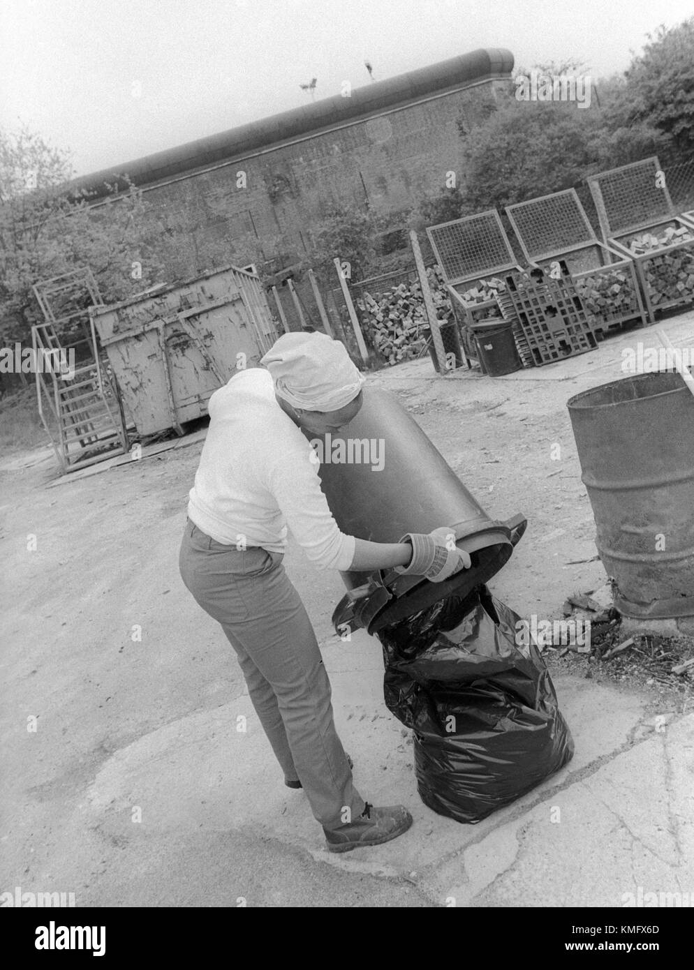 Female inmate disposing of rubbish in prison grounds, HMP Winchester, Winchester, Hampshire, United Kingdom. 10 May 2001. Stock Photo