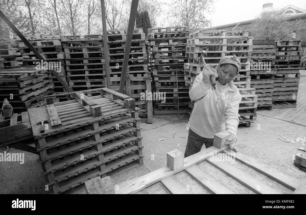 Female inmate mending wooden pallets in prison grounds, HMP Winchester, Winchester, Hampshire, United Kingdom. 10 May 2001. Stock Photo
