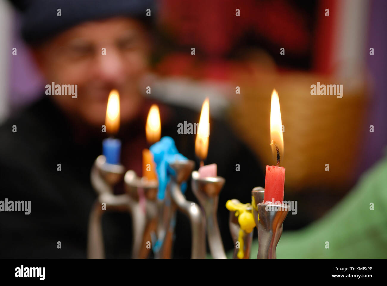 Hanukkah menorah background. Closeup of candles burning during the celebration of Hanukkah, a Jewish holiday, old man watch in the background. Stock Photo