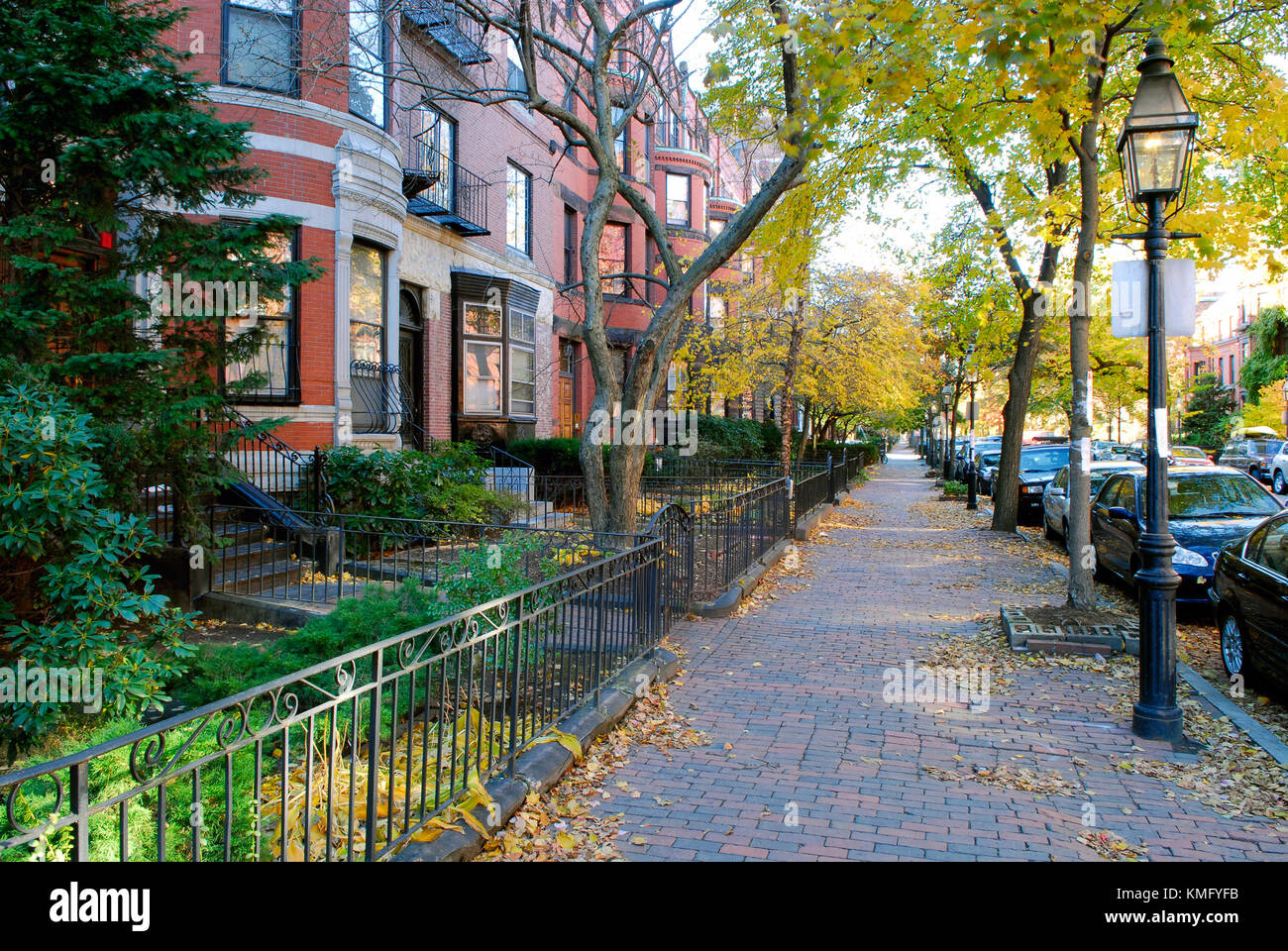 Back Bay Boston in the fall. Victorian townhouses, iron fences, brick sidewalk, street lamps, fall foliage. Stock Photo