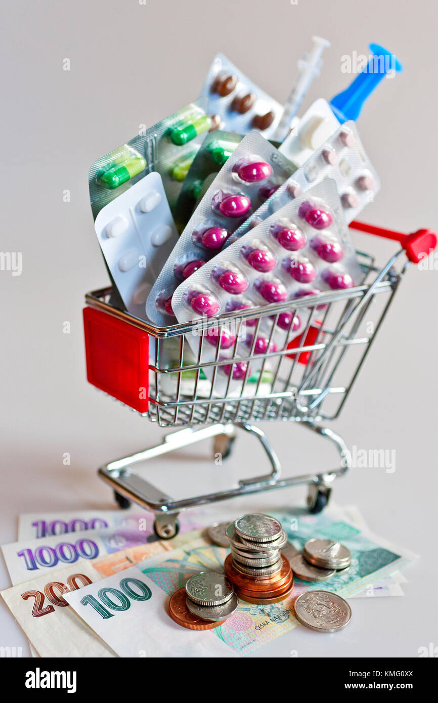 czech healthcare and medicine - financial expenses for health - money, shopping trolley and medicaments like tablets, pills and capsule - pharmacy cos Stock Photo