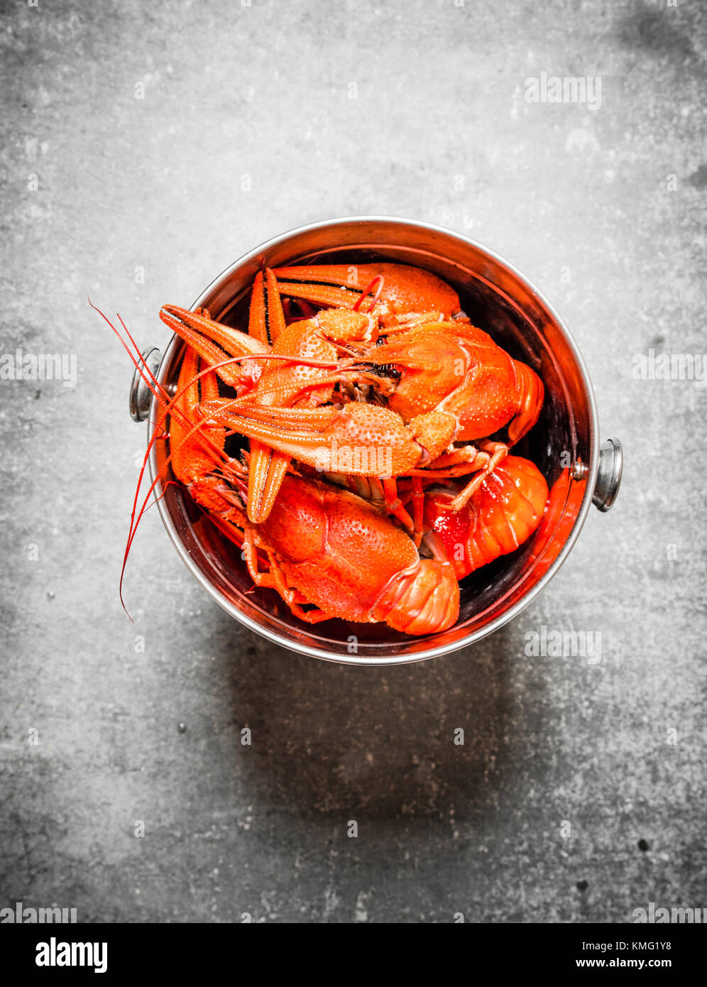 Boiled crawfish in a steel bucket. On a stone background Stock Photo