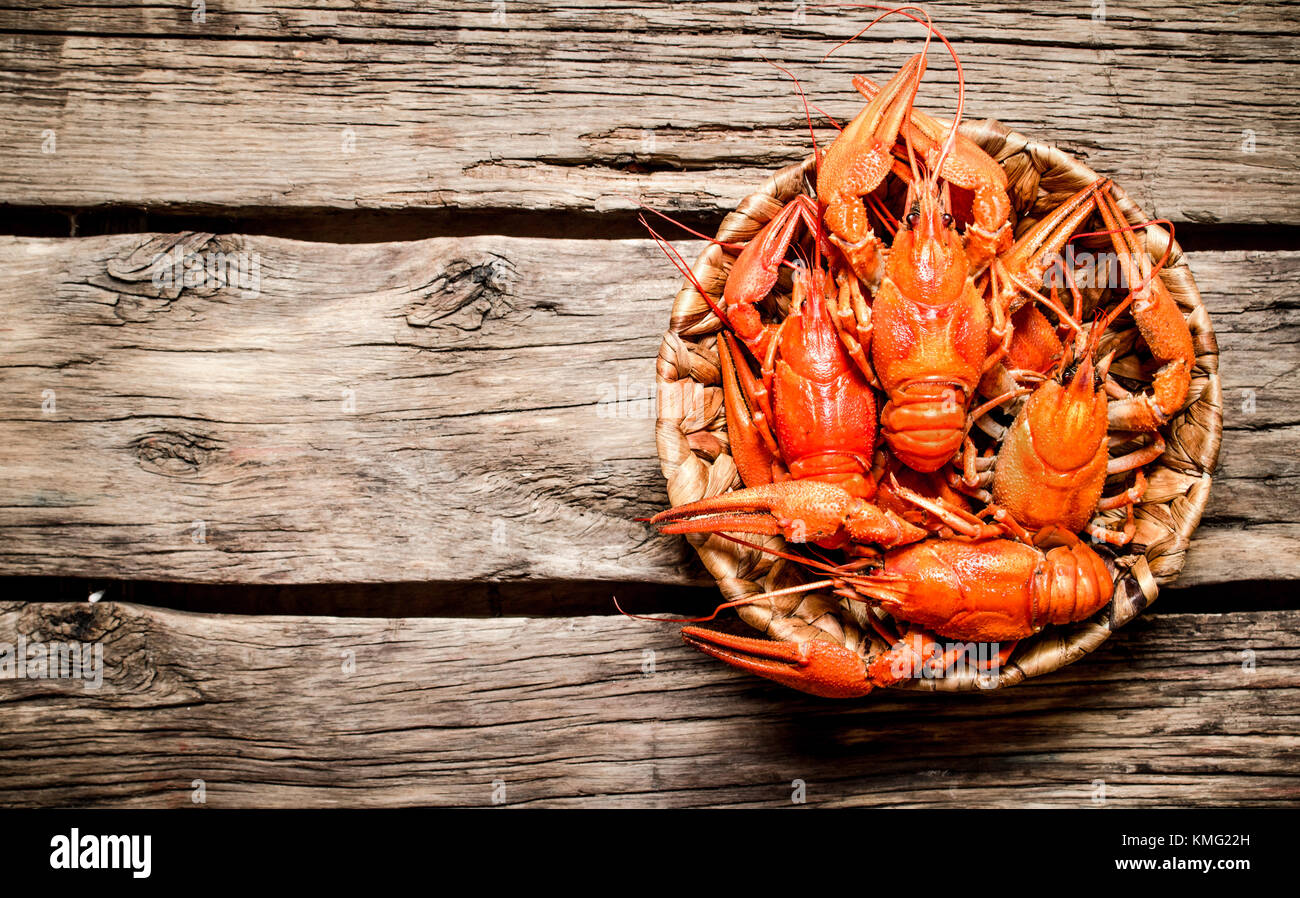Boiled crawfish in the basket. On Wooden background. Stock Photo