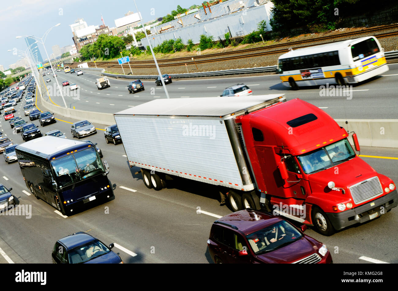 Red cargo truck in the highway coming out of the city Stock Photo
