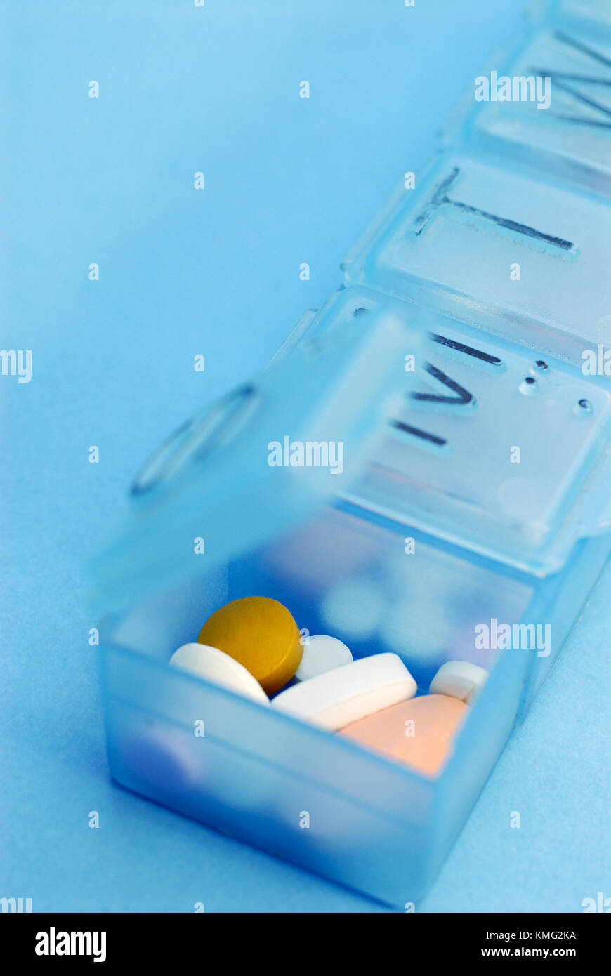 Pill Organizer Isolated on Blue Background Stock Photo
