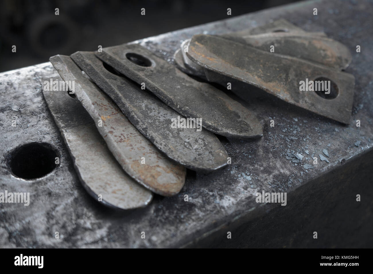 Harvester blades on anvil at blacksmith shop Stock Photo