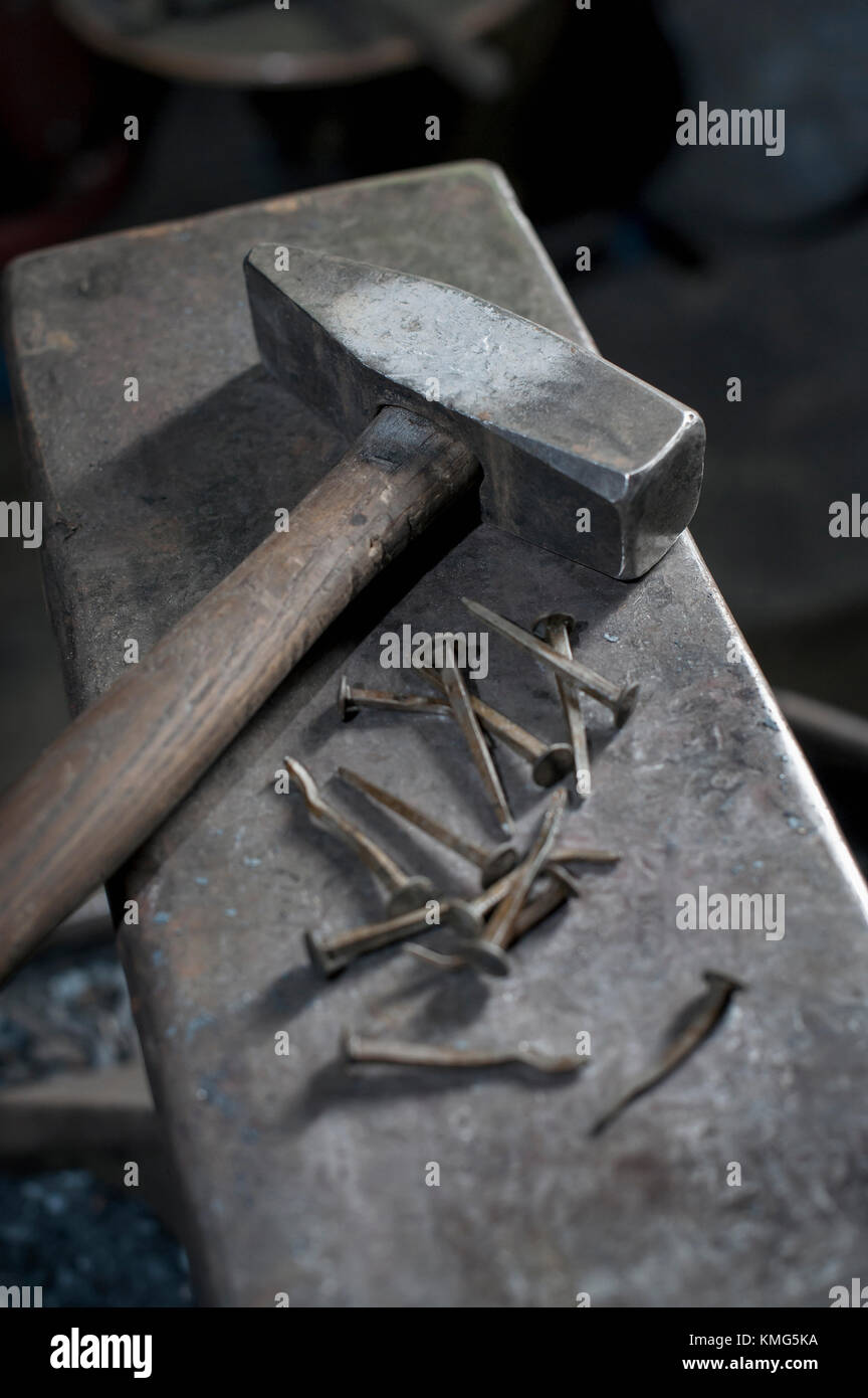Hammer and nail on anvil at blacksmith shop Stock Photo