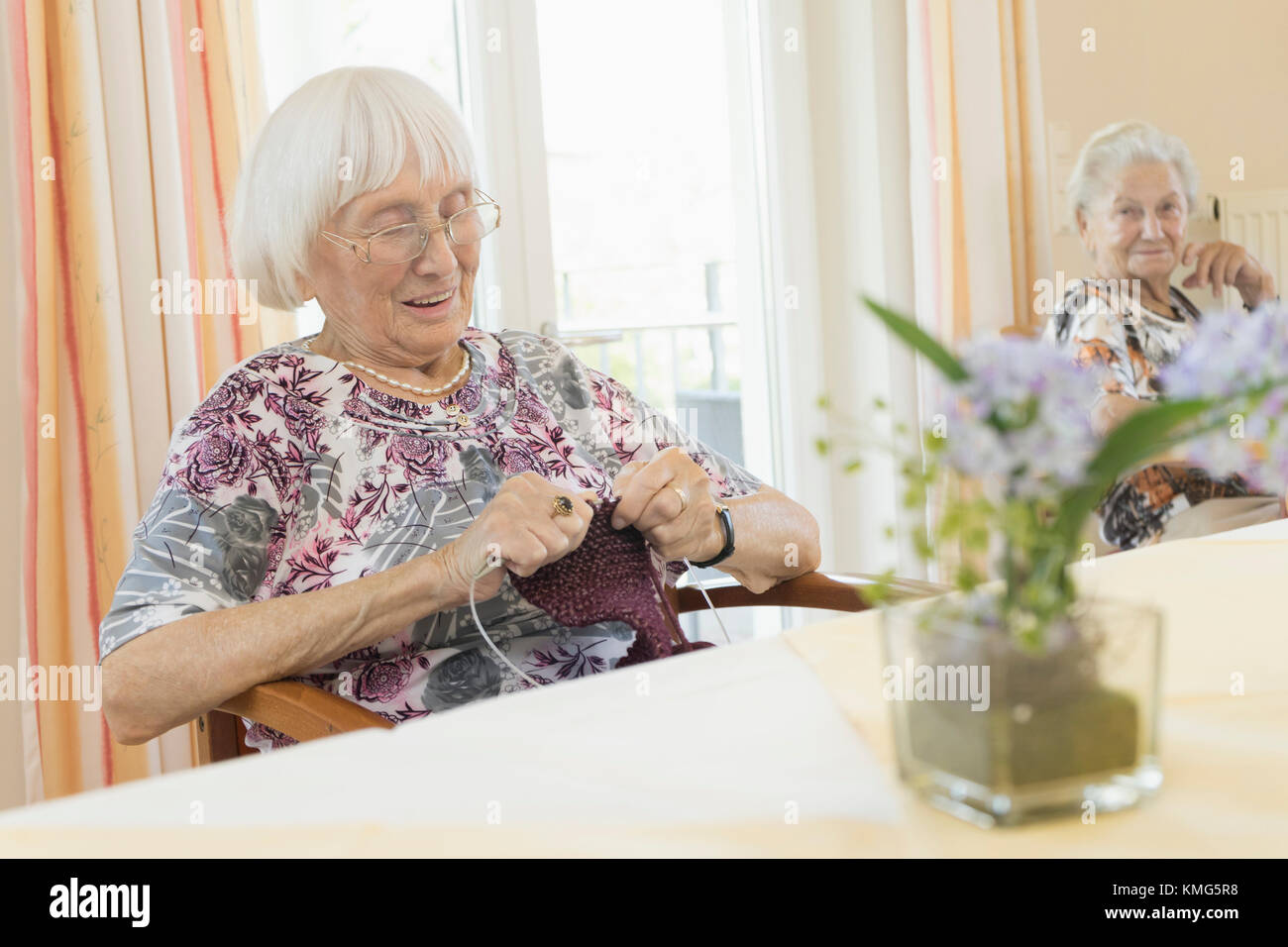 Senior woman crocheting in rest home Stock Photo