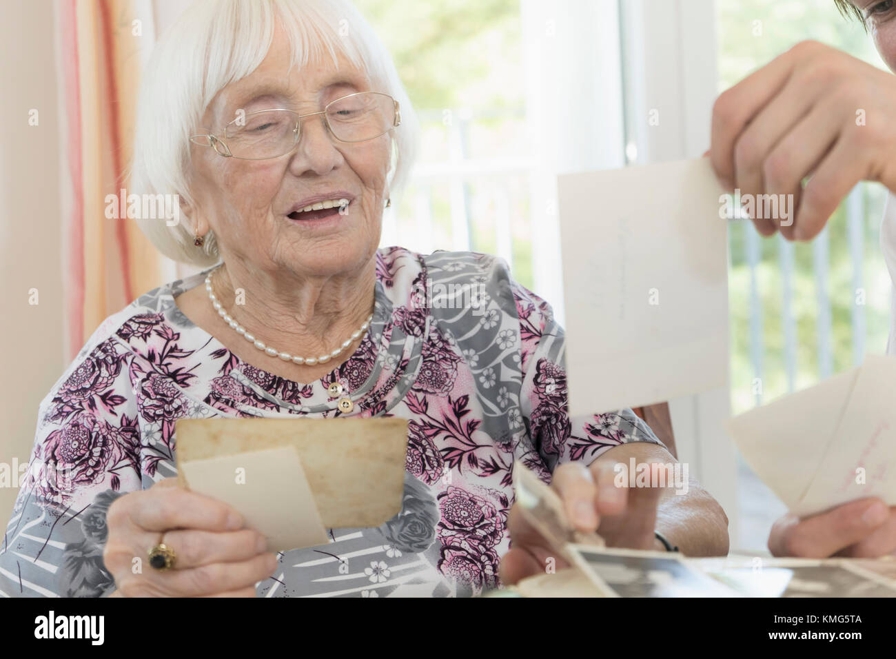 Senior woman watching photos with caretaker in rest home Stock Photo