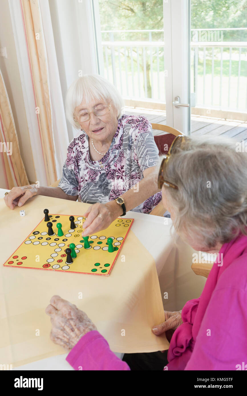Senior women playing board game in rest home Stock Photo