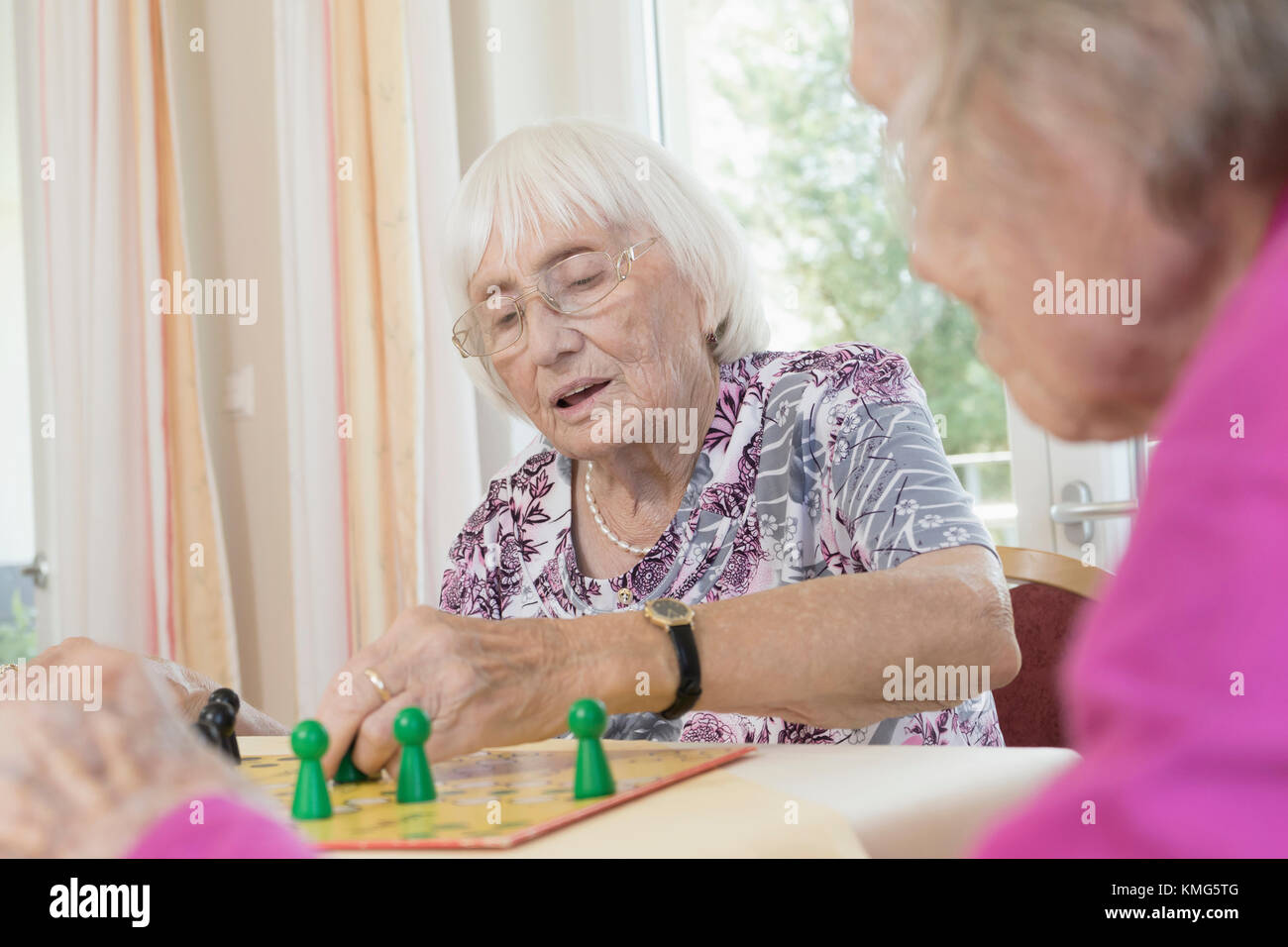 Senior women playing board game in rest home Stock Photo