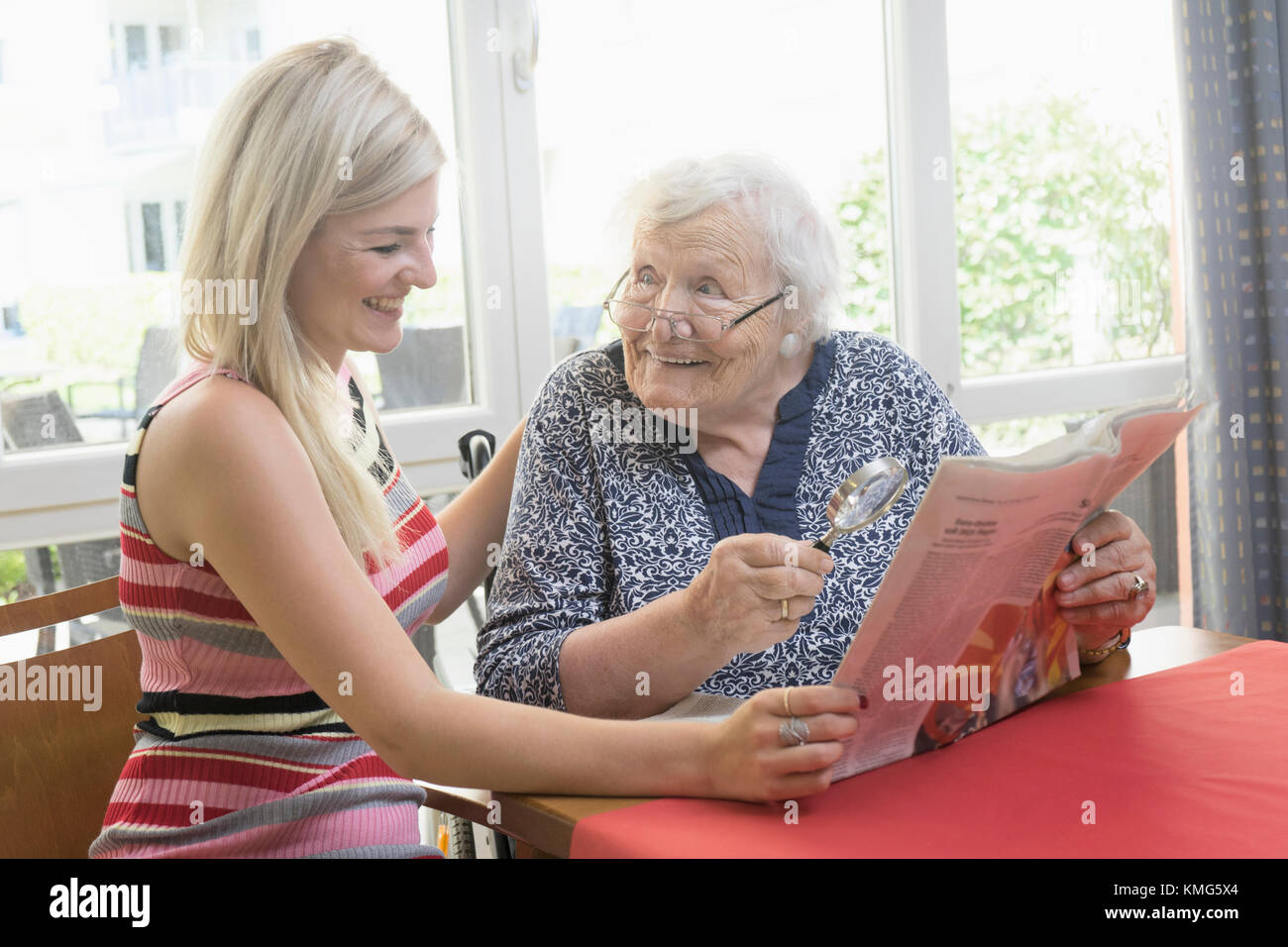 Senior woman reading newspaper with her daughter Stock Photo