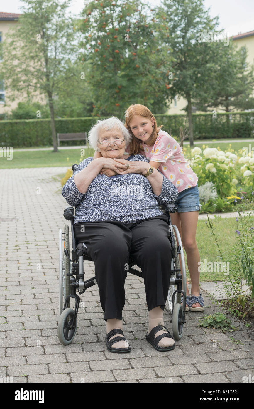Senior woman on wheelchair with granddaughter at rest home park Stock Photo