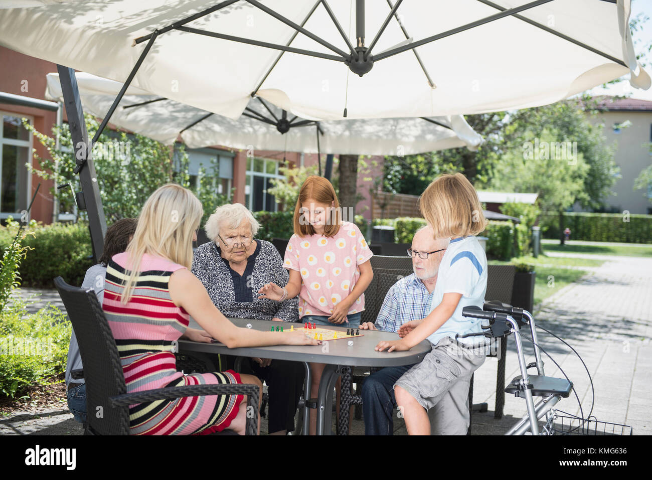 Multi-generation family playing board game at nursing home Stock Photo