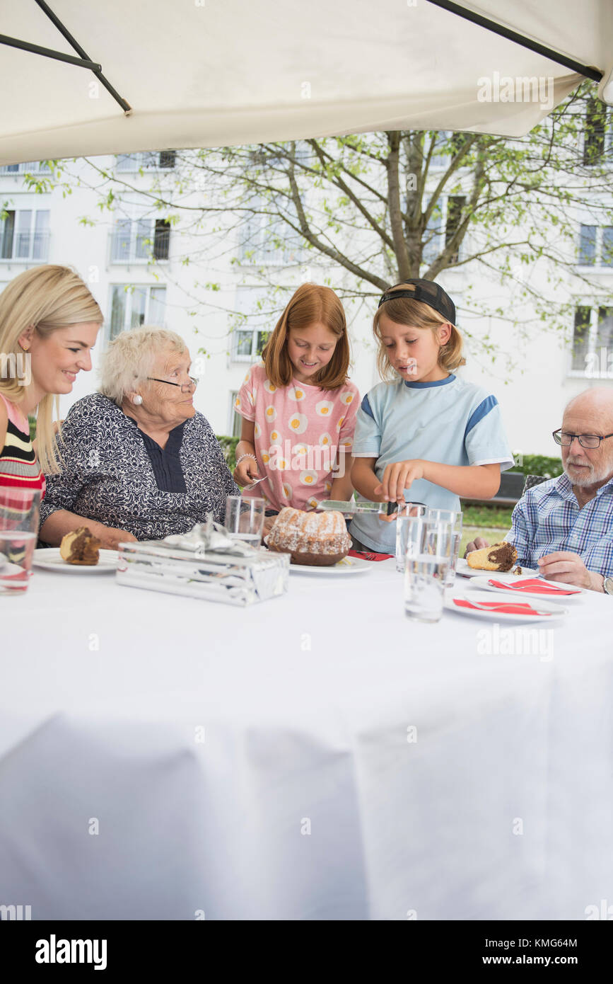 Children cutting cake on dining table Stock Photo