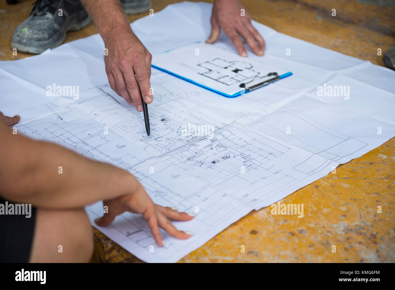 Architect discussing blueprint with construction worker at building ...