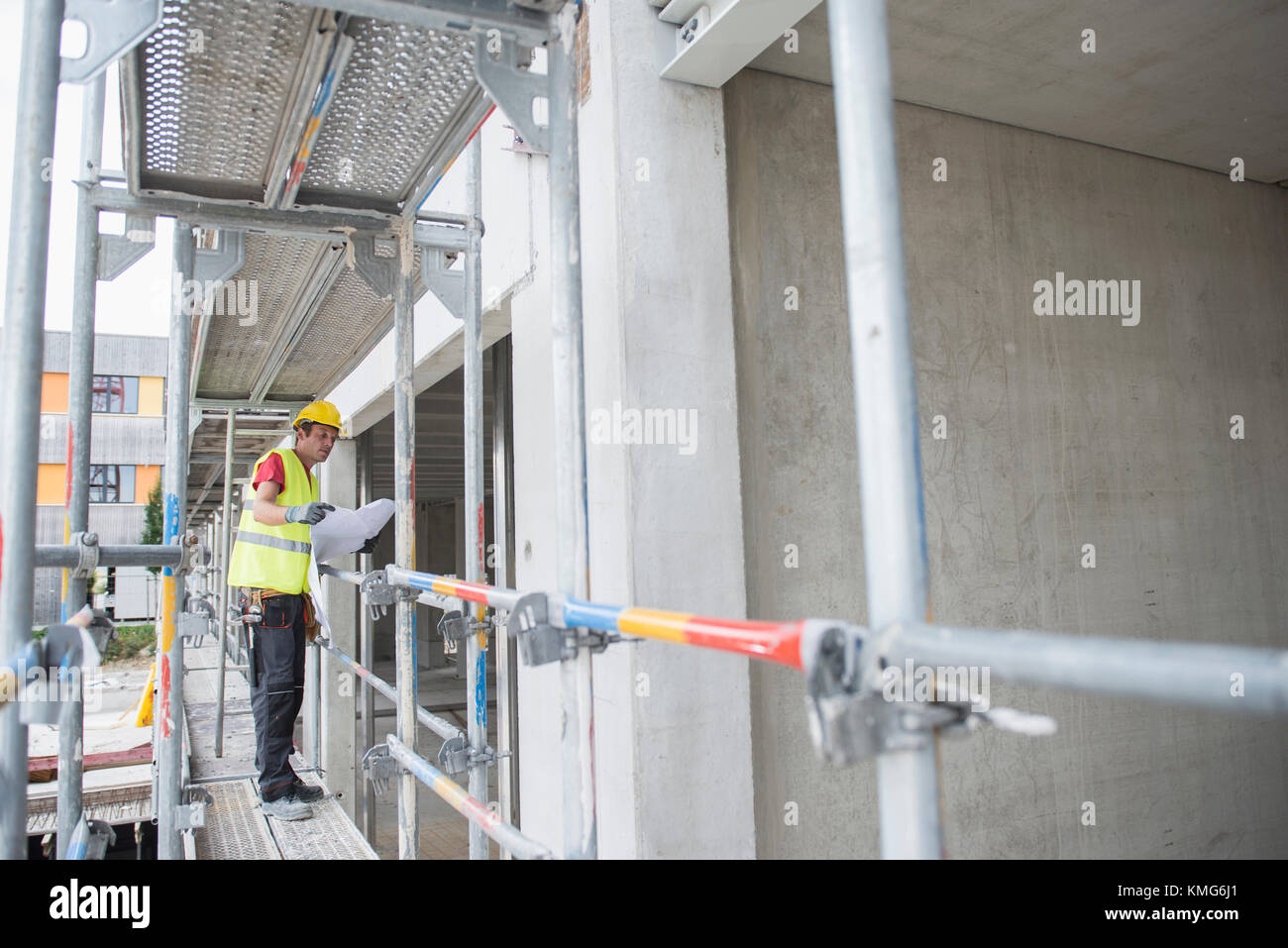 Construction worker holding blueprint at construction site Stock Photo ...