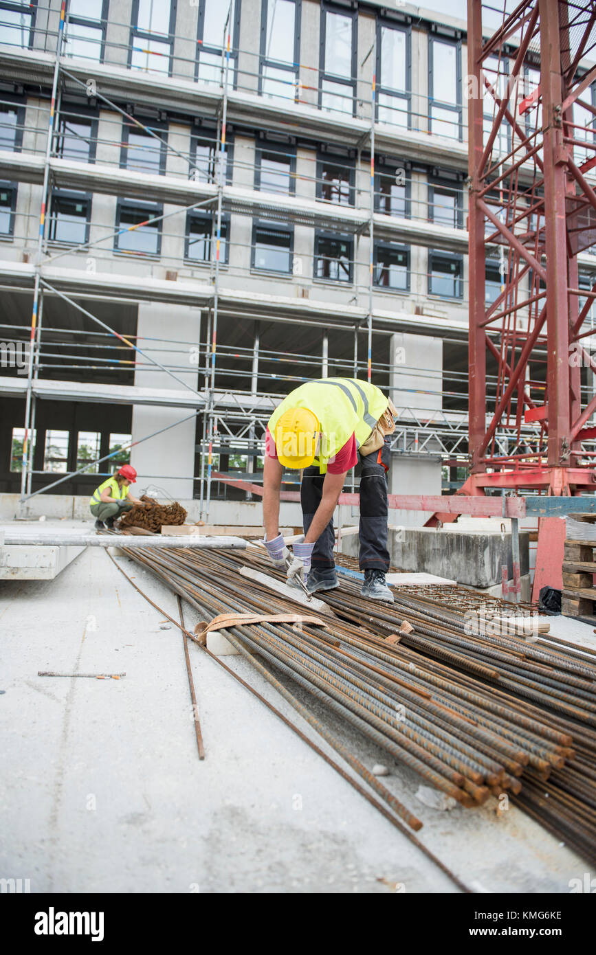 Construction workers working at building site Stock Photo - Alamy