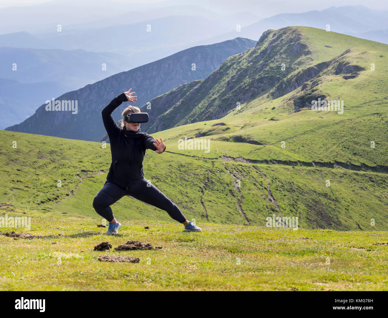 Woman practicing karate moves with virtual reality glasses on mountain Stock Photo