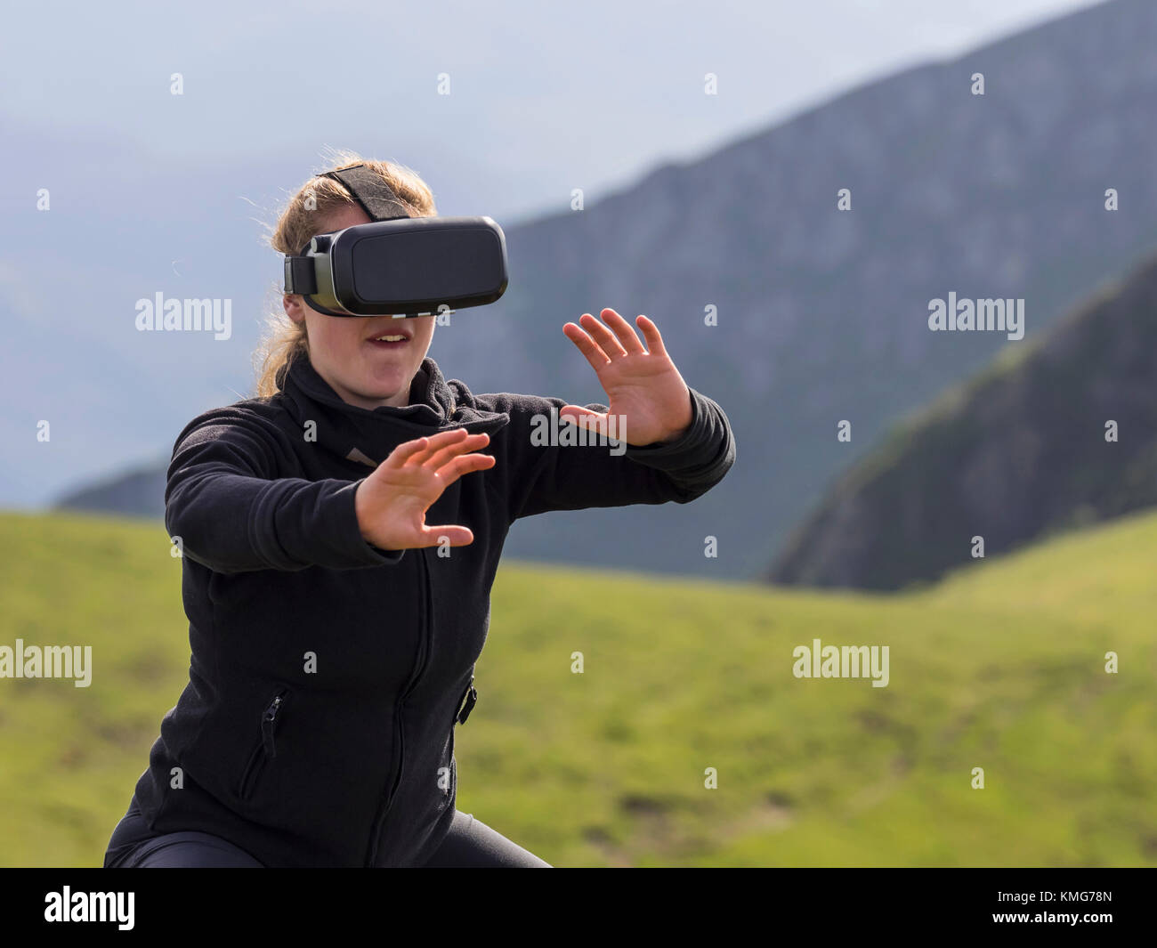 Woman practicing karate moves with virtual reality glasses on mountain Stock Photo