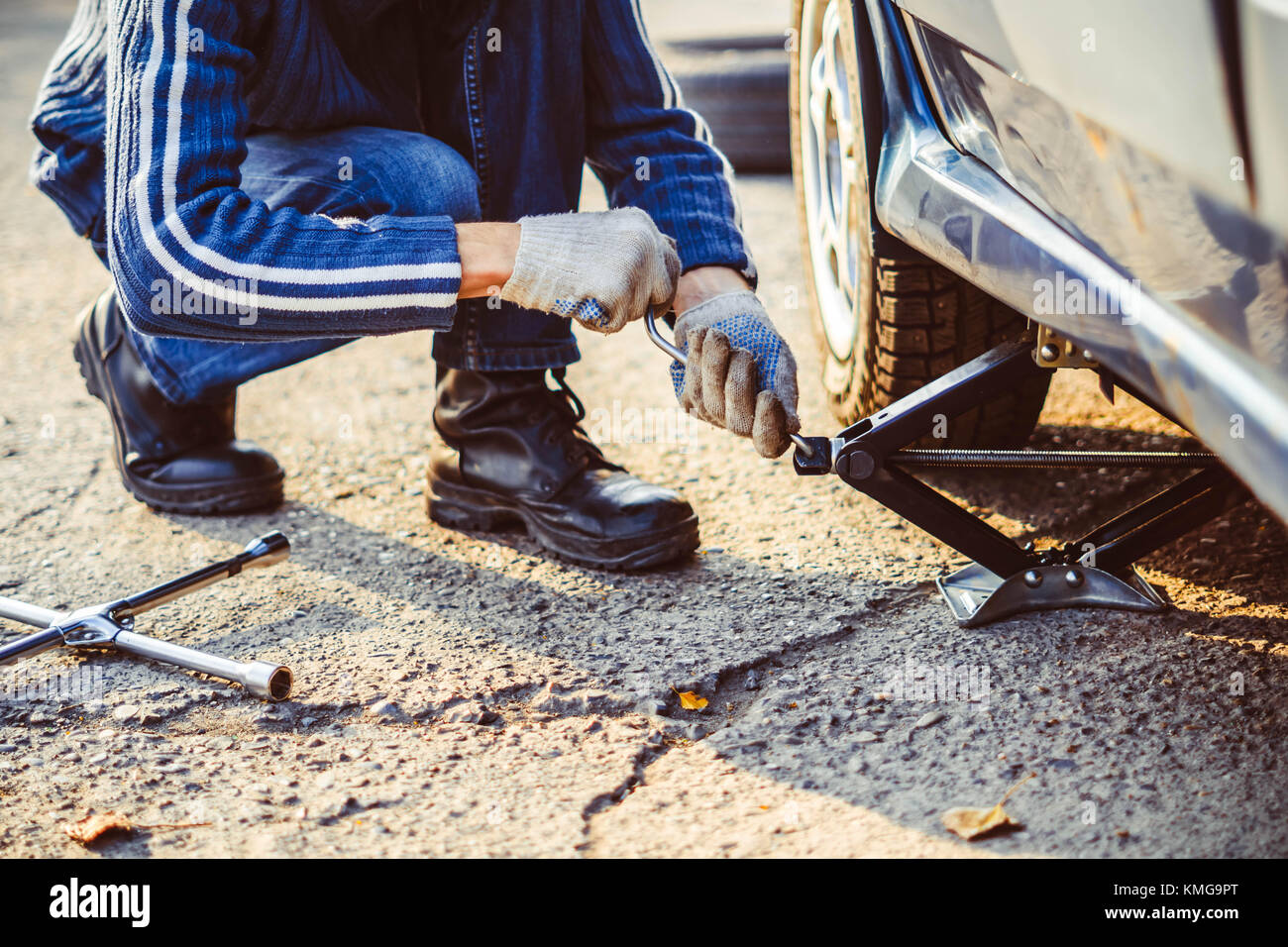 Jacking up a car to change a tyre after a roadside puncture with the