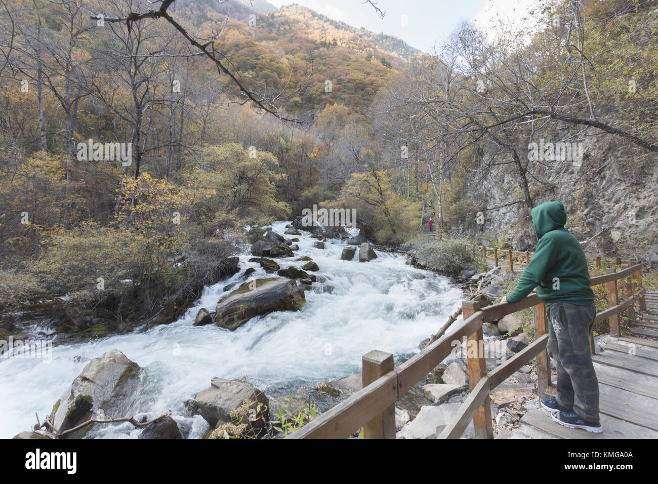 A man with green clothes looked at the flowing stream Stock Photo
