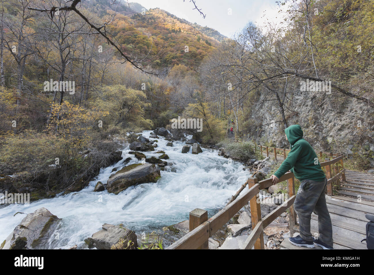 A man with green clothes looked at the flowing stream Stock Photo