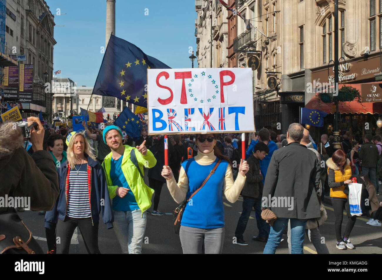 Anti Brexit demonstration. Young woman holding colourful banner with 'Stop Brexit', man pointing at banner and EU flag behind Stock Photo