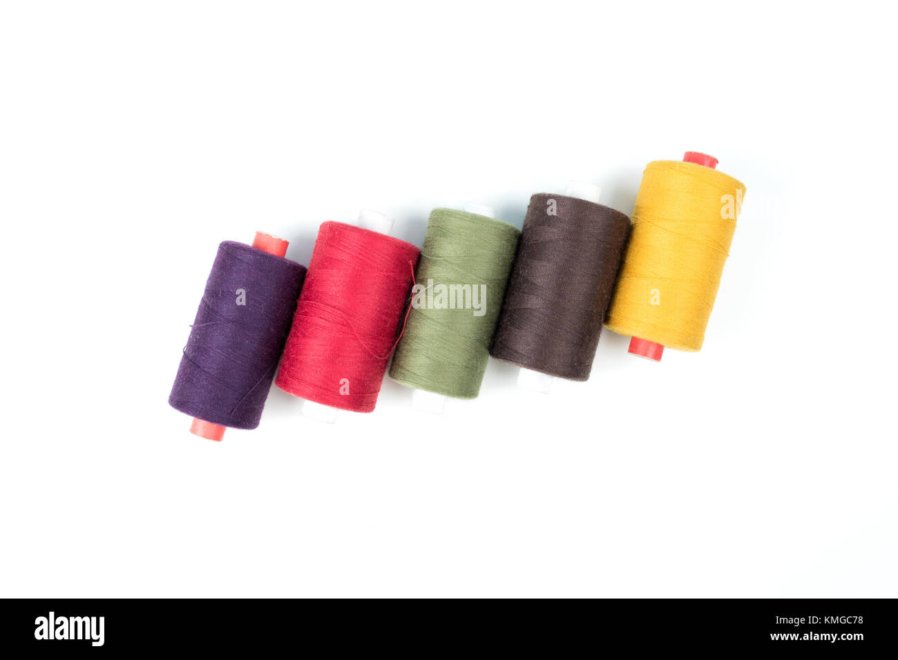 Colored thread coils on white background, sewing accessories Stock Photo