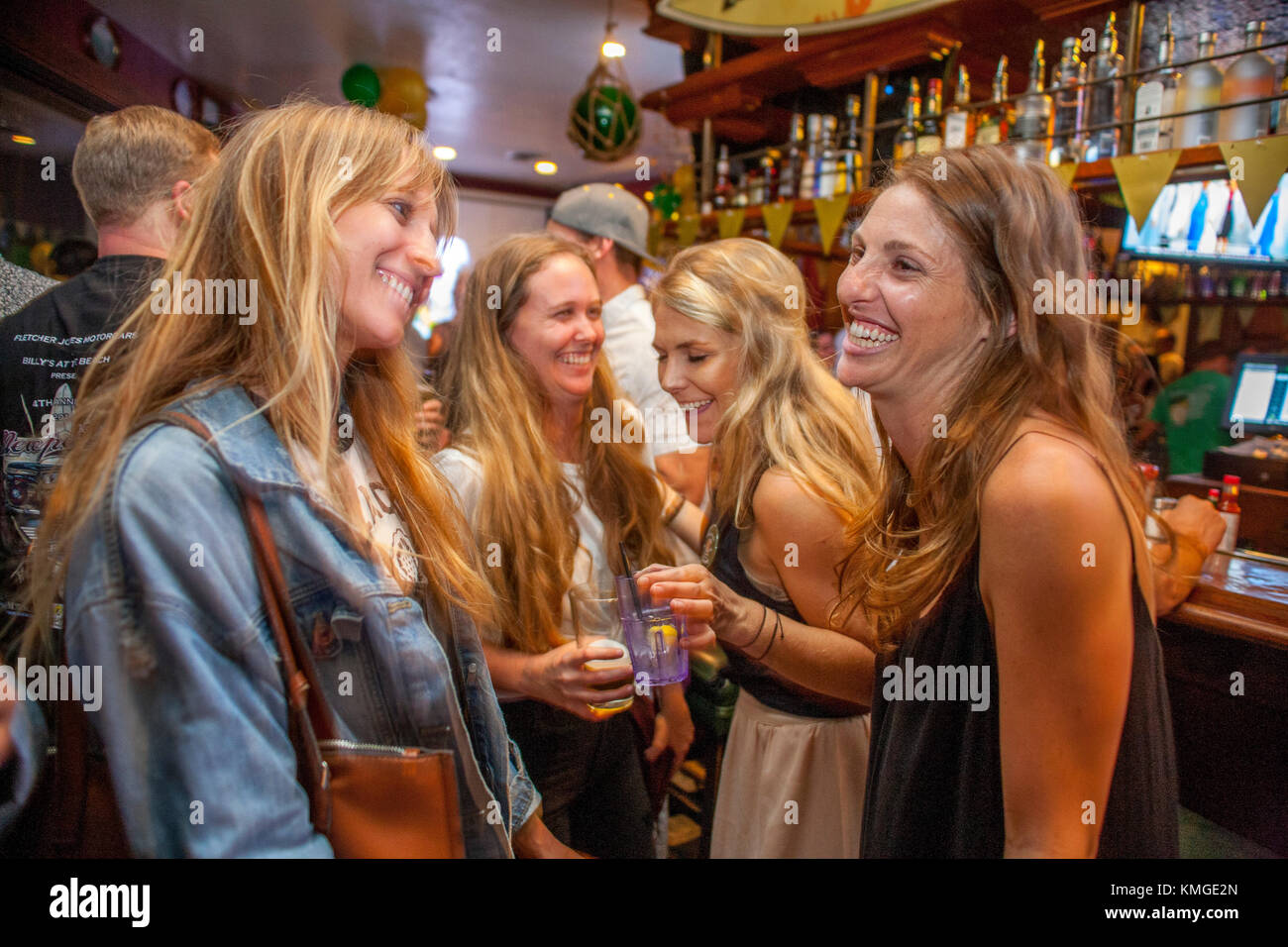 Enjoying their beer, four young adult women dance to recorded music in a Newport Beach, CA, Irish bar. Stock Photo
