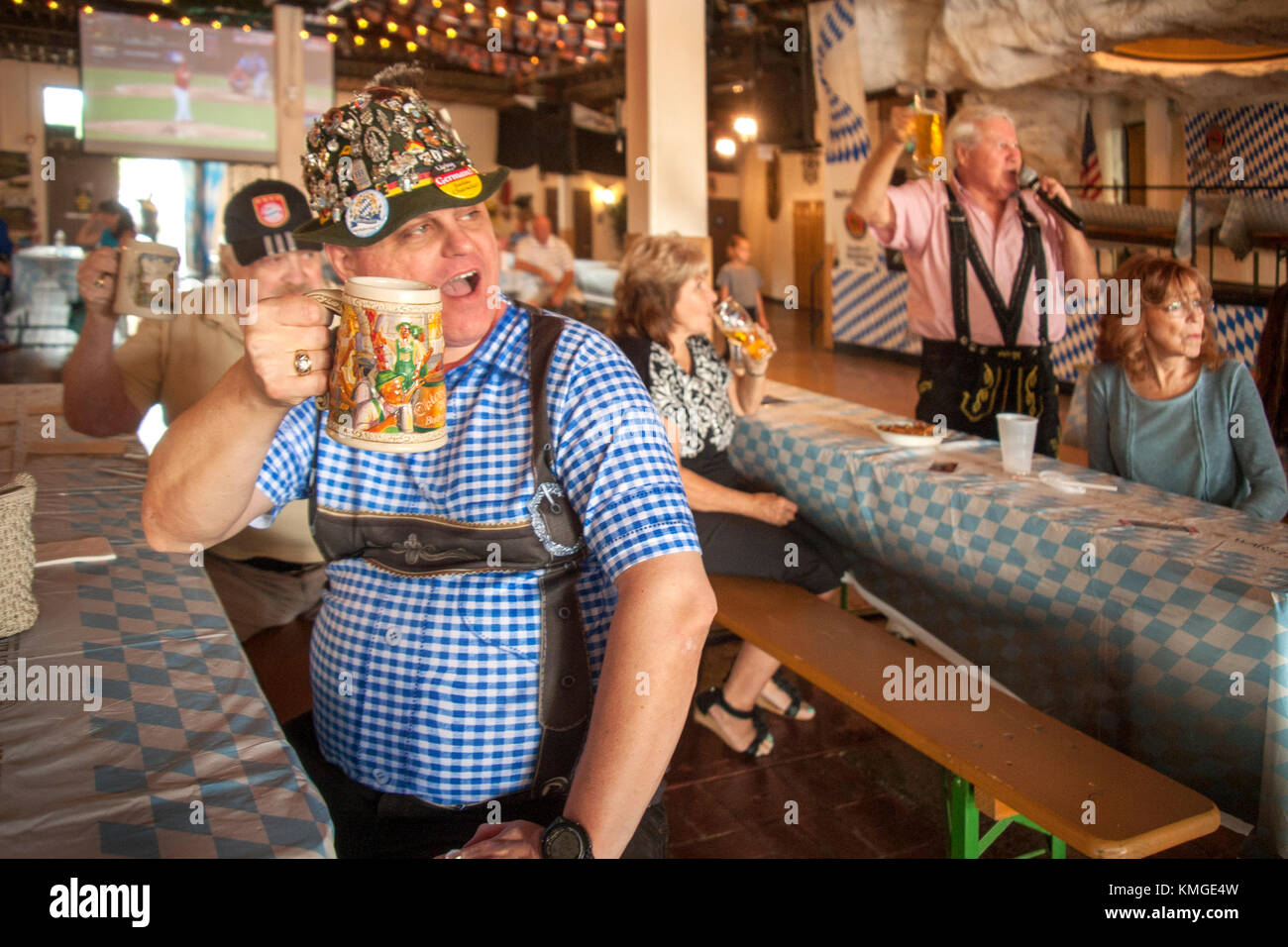 Wearing a Tyrolean hat, an Oktoberfest celebrant enjoys beer hall
