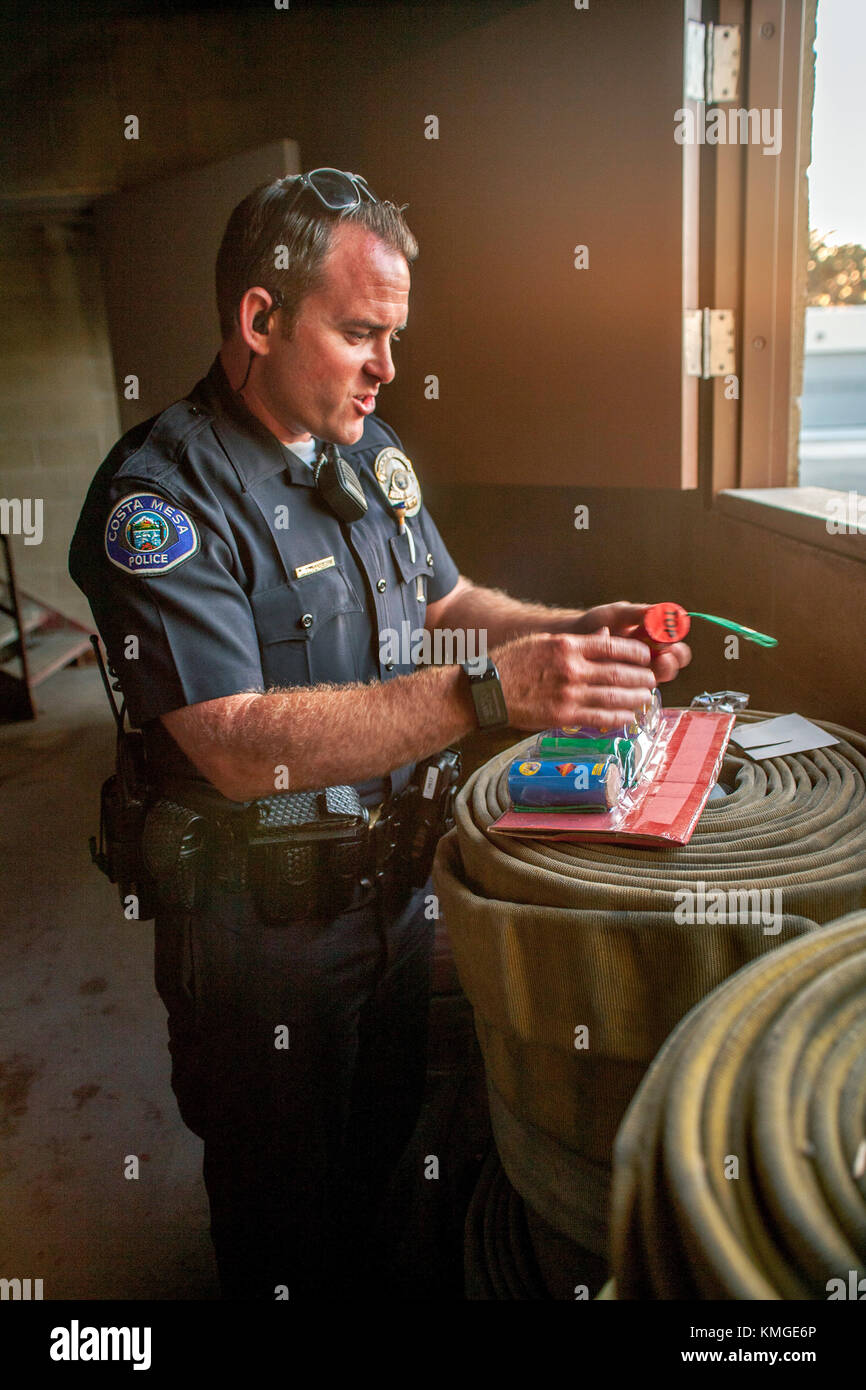 A Costa Mesa, CA, policeman inspects confiscated dangerous illegal fireworks at a department training facility. Stock Photo