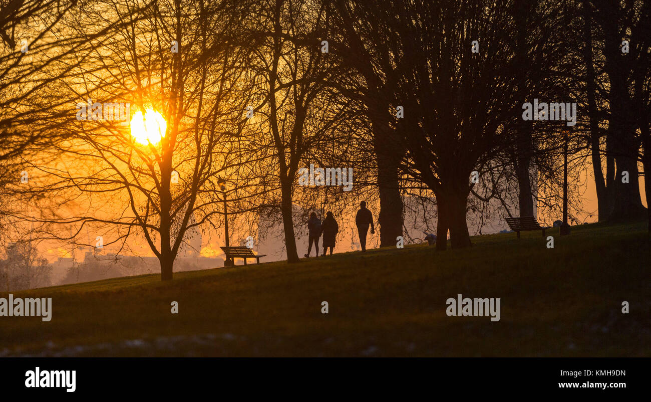 London, UK. 12th Dec, 2017. London, December 12 2017. Walkers on Primrose Hill as the sun rises on a clear very cold morning in London. Credit: Paul Davey/Alamy Live News Stock Photo