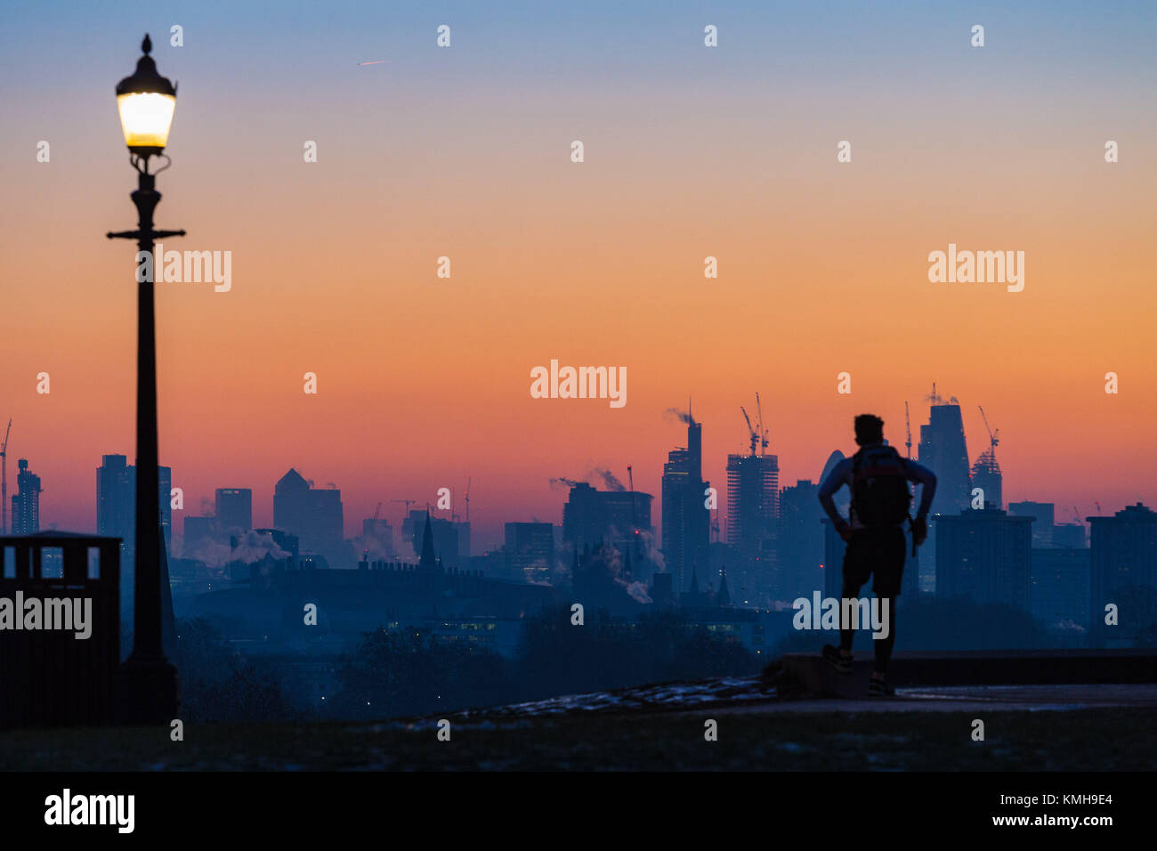 London, UK. 12th Dec, 2017. London, December 12 2017. An early riser awaits the sunrise on a clear very cold morning in London, seen from Primrose Hill in Camden. Credit: Paul Davey/Alamy Live News Stock Photo