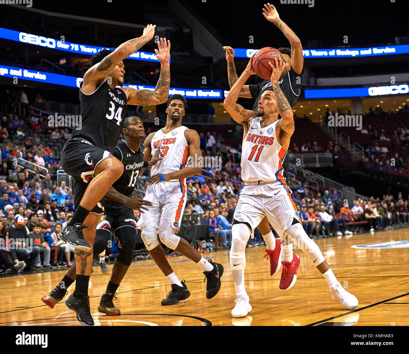 Newark, New Jersey, USA. 9th Dec, 2017. Florida's guard Chris Chiozza (11) drives to the basket as Cincinnati's guard Jarron Cumberland (34) defends in the first half during the Never Forget Tribute Classic between the Cincinnati Bearcats and the Florida Gators at the Prudential Center in Newark, New Jersey. Florida defeated Cincinnati 66-60. Duncan Williams/CSM/Alamy Live News Stock Photo