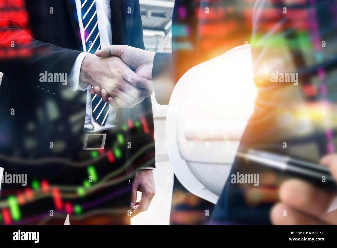 Fintech technology concept. Double exposure of business men handshake and blur stock market graph trading screen. Stock Photo