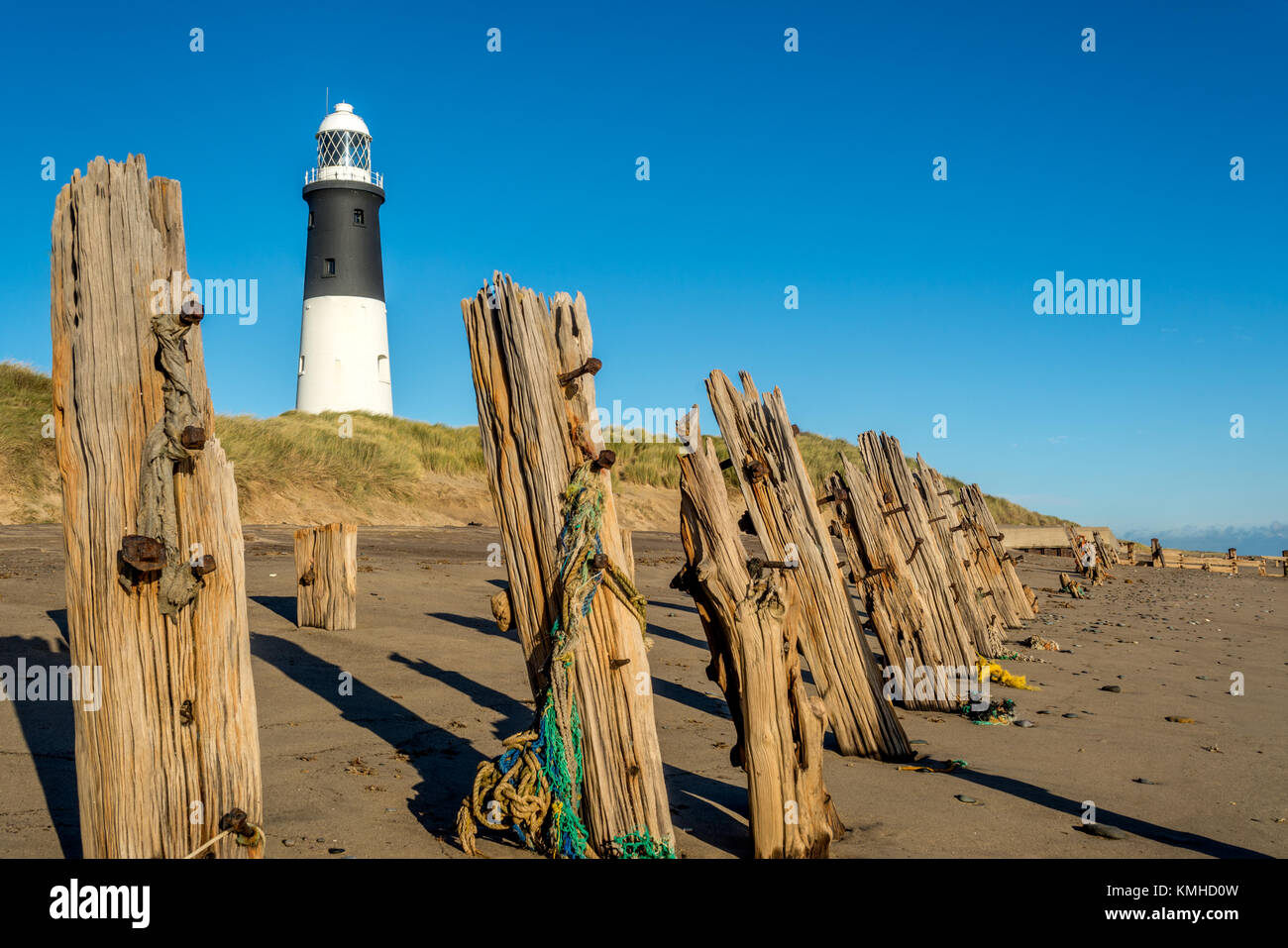 Spurn Point lighthouse and old wooden beach sea defences Stock Photo