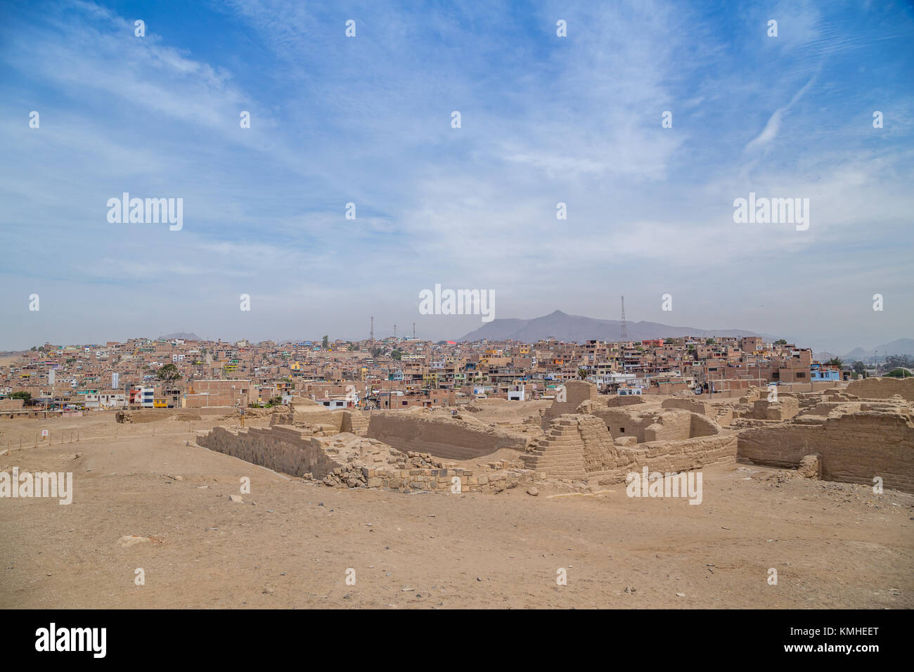 Modern favelas encroaching on the historic temples of Pachacamac - an ancient archaeological complex south of Lima, Peru in South America Stock Photo