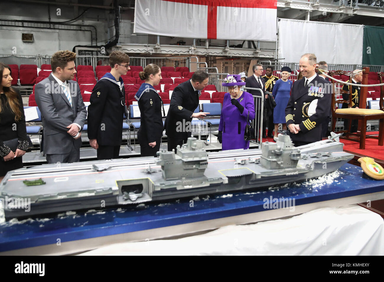 Queen Elizabeth II, and the ship's Captain, Commodore Jerry Kyd (right), view a cake HMS Queen Elizabeth, during the commissioning of HMS Queen Elizabeth, Britain's biggest and most powerful warship, into the Royal Navy Fleet at Portsmouth Naval Base. Stock Photo