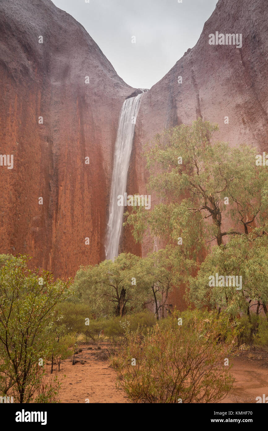 Ayers Rock in the rain - waterfalls on Uluru during a rare rainstorm in Uluru Kata Tjuta National Park, Northern Territory, Australia Stock Photo